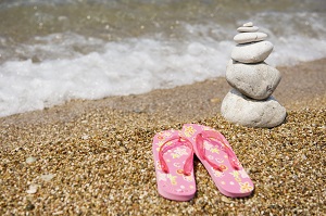Zapatillas y piedras en la arena de una playa