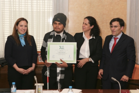 El ganador del Concurso 'FOAL y Yo' en la modalidad de audio, Ariel Ruiz, sostiene una placa acreditativa durante el último Patronato de FOAL acompañado por el presidente y la vicepresidenta de FOAL, así como de una representante de la Embajada de Paraguay en España