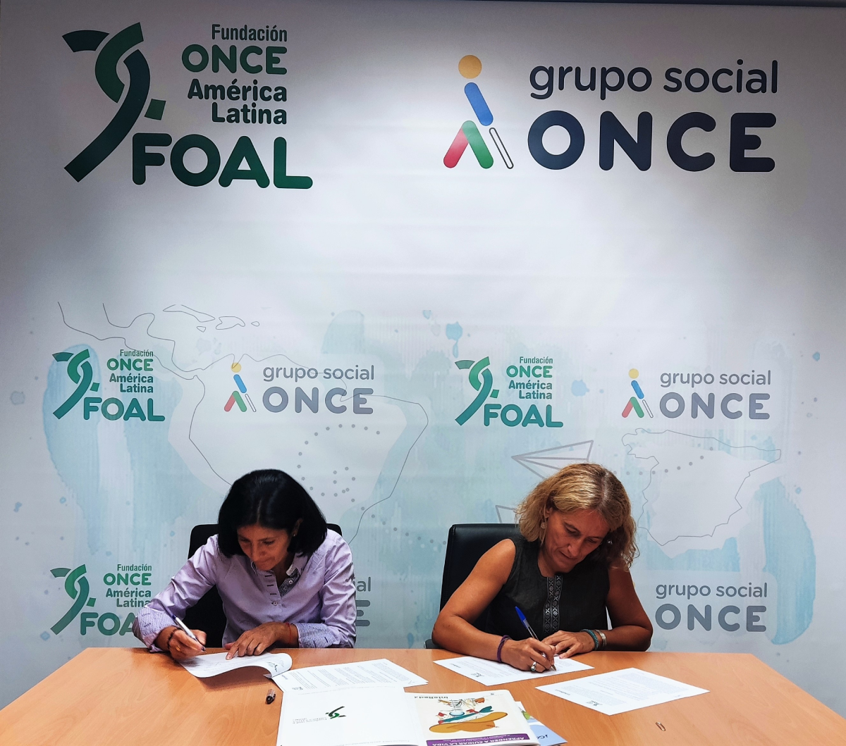 Las directoras de FOAL e InteRed, Estefanía Mirpuri y Ana Arancibia, firman el acuerdo en las oficinas de FOAL