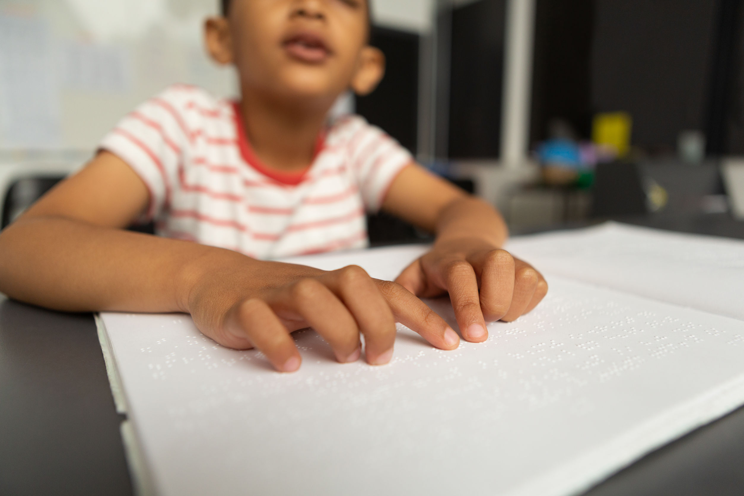 Un niño de unos 8 años lee en braille