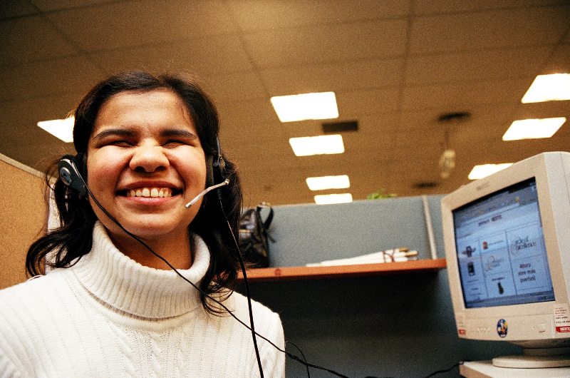 Una joven con discapacidad visual, en su puesto de trabajo frente a una computadora