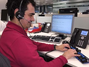 Un joven ciego en su puesto de trabajo donde usa adaptaciones a su puesto
