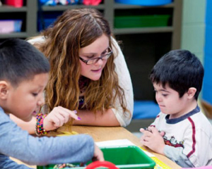 Una profesora dando clase a dos niños